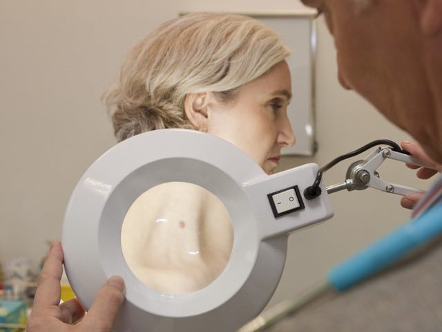 Dermatologist examining a female patient